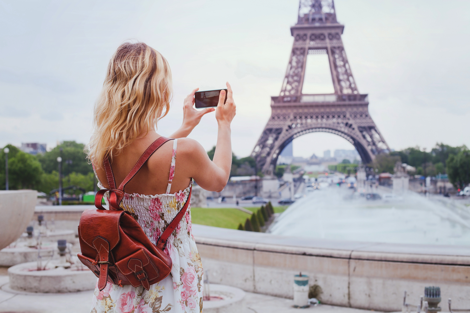 tourist taking photo of Eiffel tower in Paris with compact camer