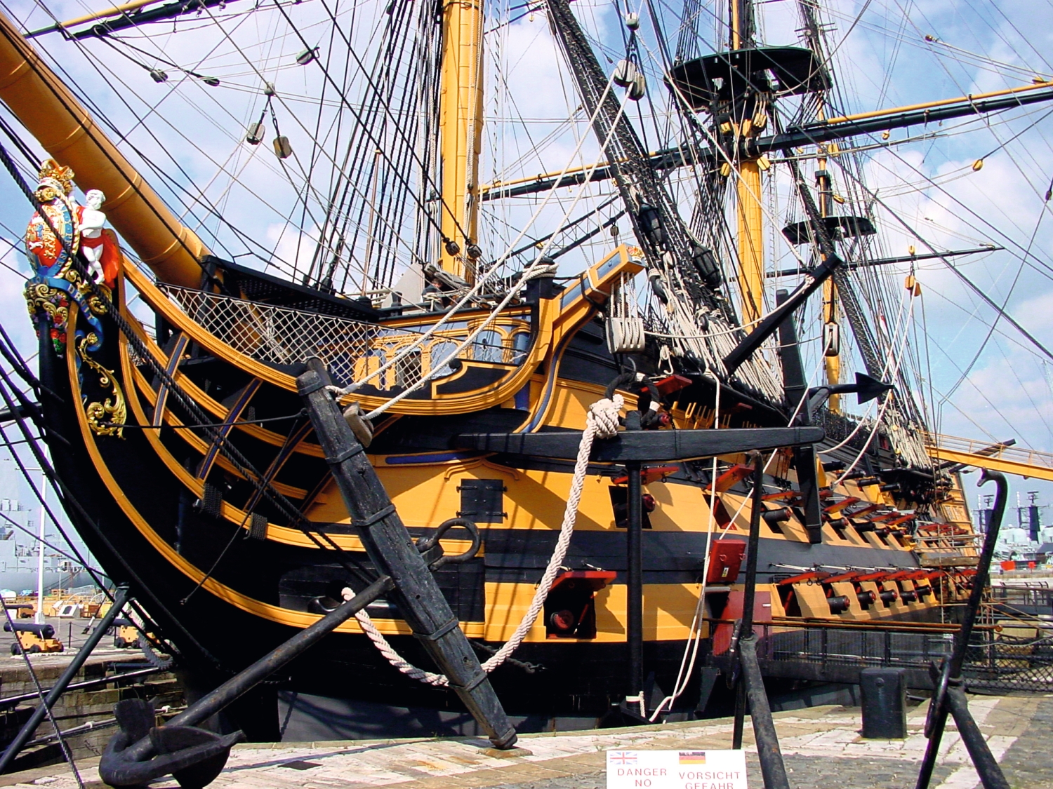 Historisches Segelschiff im Hafen mit reich verziertem Bug.
