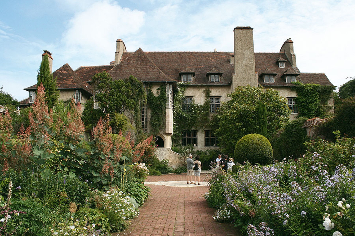 Herrenhaus mit Garten im Parc du Bois des Moutiers, umgeben von blühenden Pflanzen.