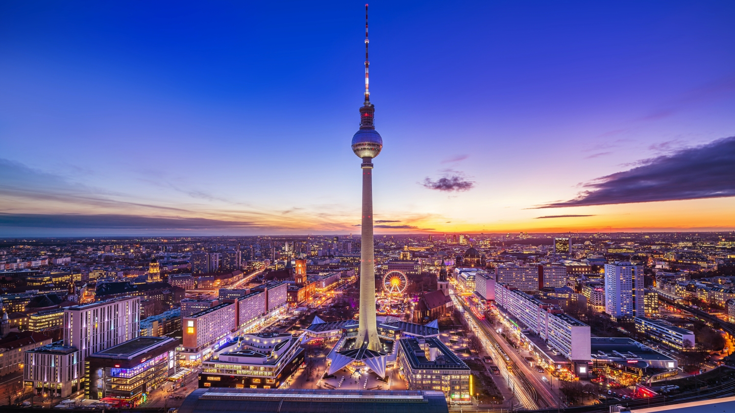 Fernsehturm Berlin bei Sonnenuntergang über der Stadtlandschaft.