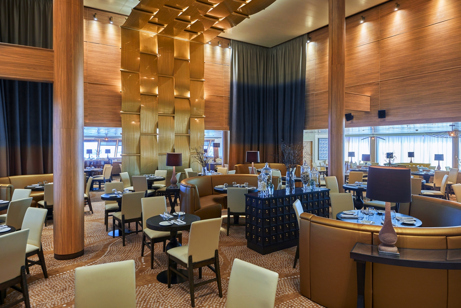 Elegantes Restaurant mit modernen Tischen und Stühlen, Holzwänden und goldener Deko.
