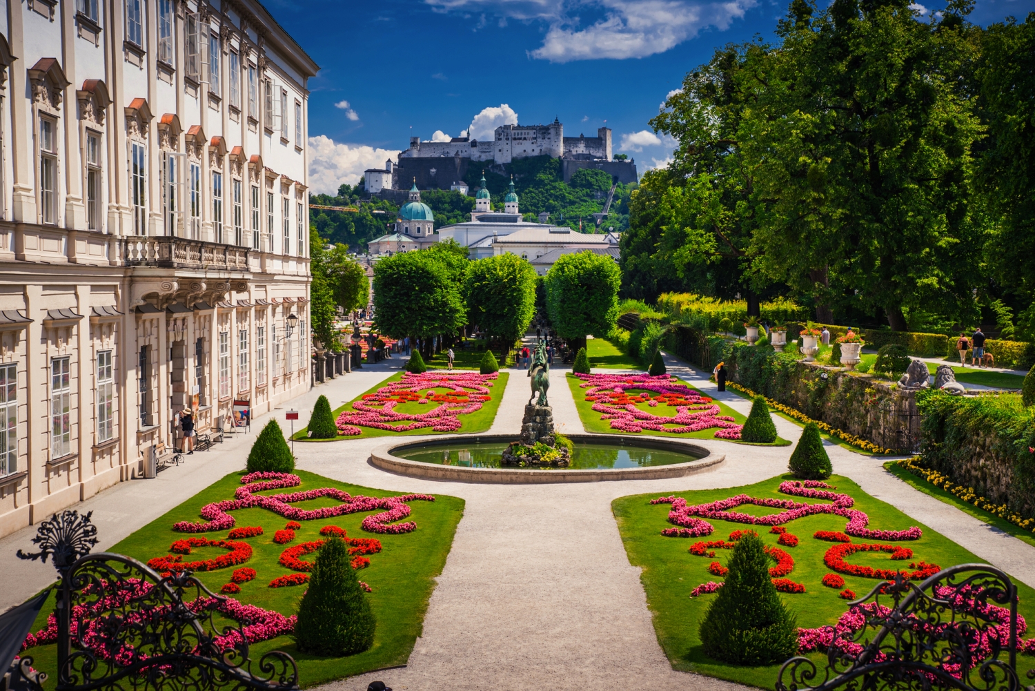 Blick auf Mirabellgarten in Salzburg, mit Festung im Hintergrund.