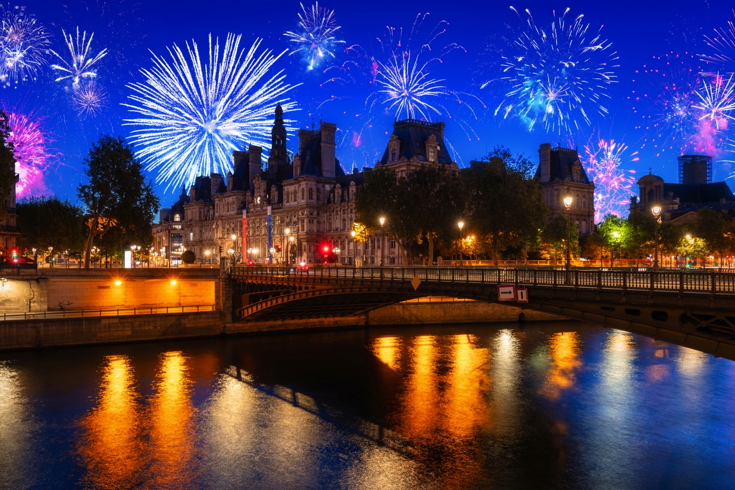 Silvester-Feuerwerk über dem Pariser Rathaus mit Blick auf die Seine bei Nacht.