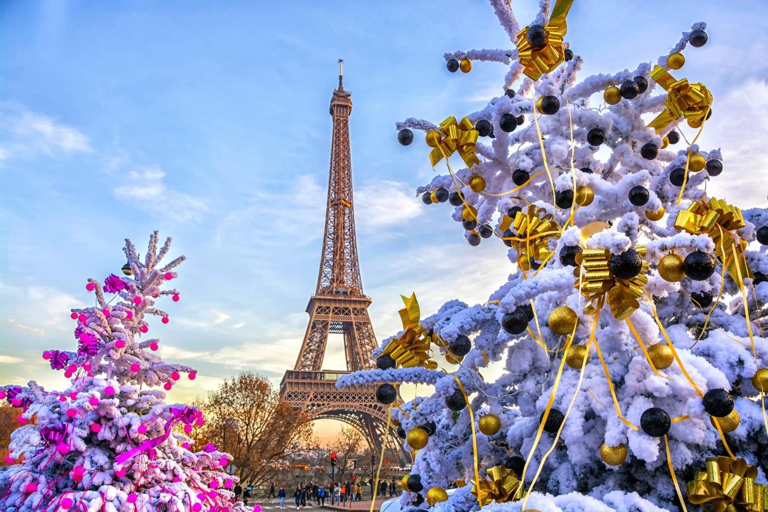© MarinadeArt - stock.adobe.com Eiffelturm im Winter vor verschneiten und weihnachtlich geschmückten Bäumen.