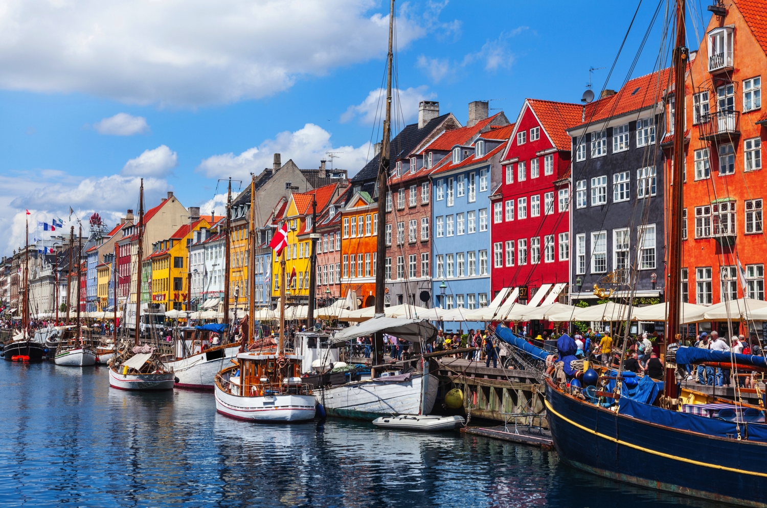 © Friedberg - stock.adobe.com Bunte Häuser und Boote am Nyhavn in Kopenhagen, der Hauptstadt Dänemarks, bei sonnigem Wetter.