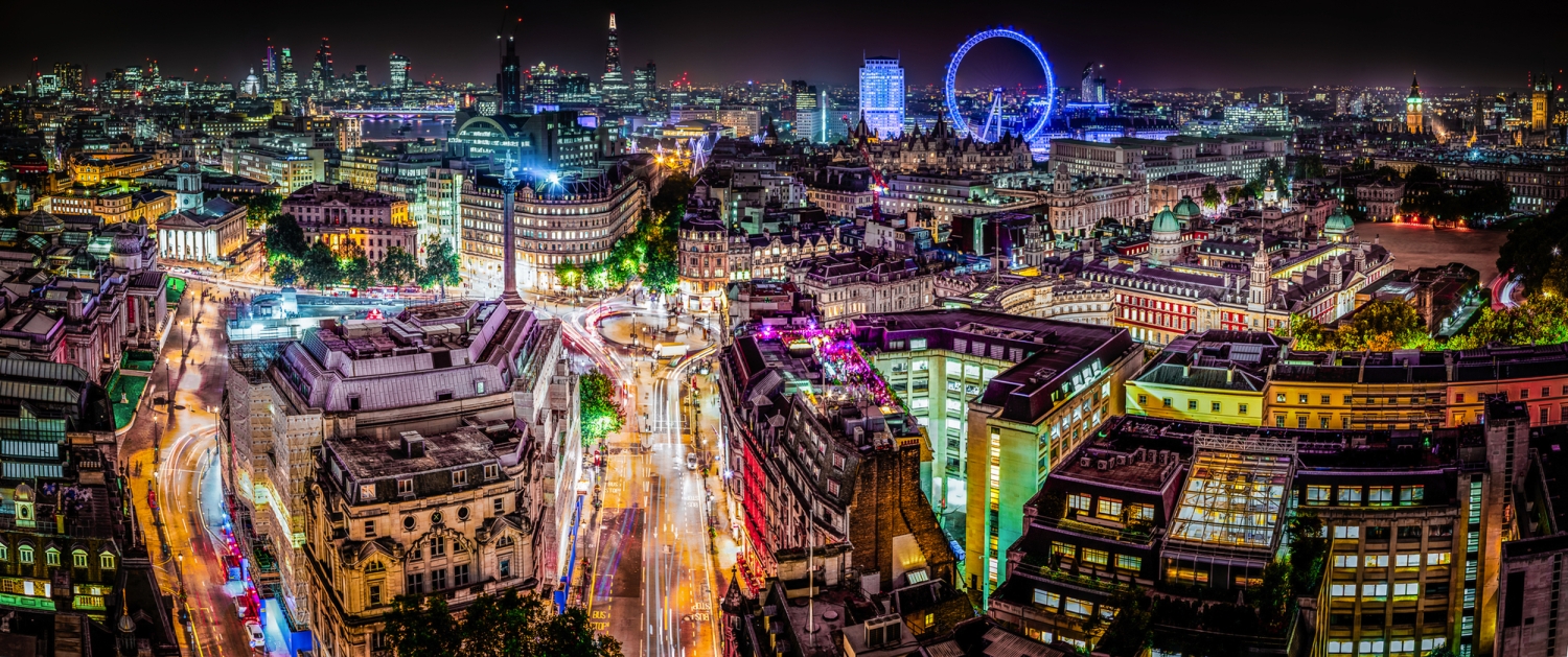 Panorama der Skyline von London bei Nacht mit Blick auf die Themse und beleuchtete Wahrzeichen.