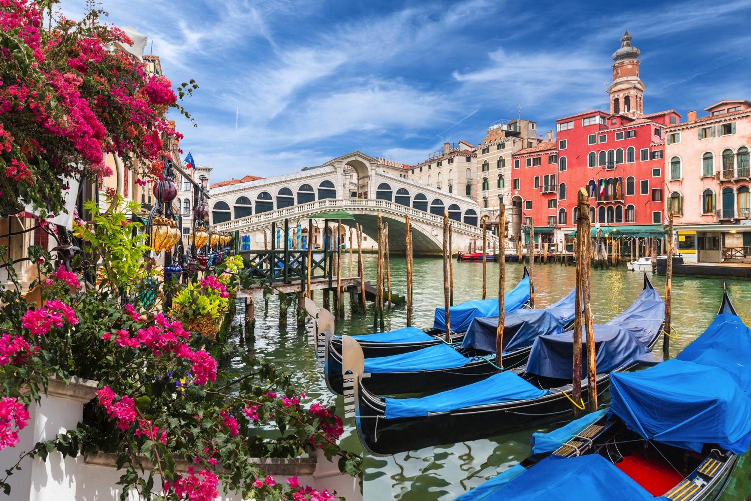 Venedig: Riala-Brücke, bunte Gebäude und Gondeln am Kanal.