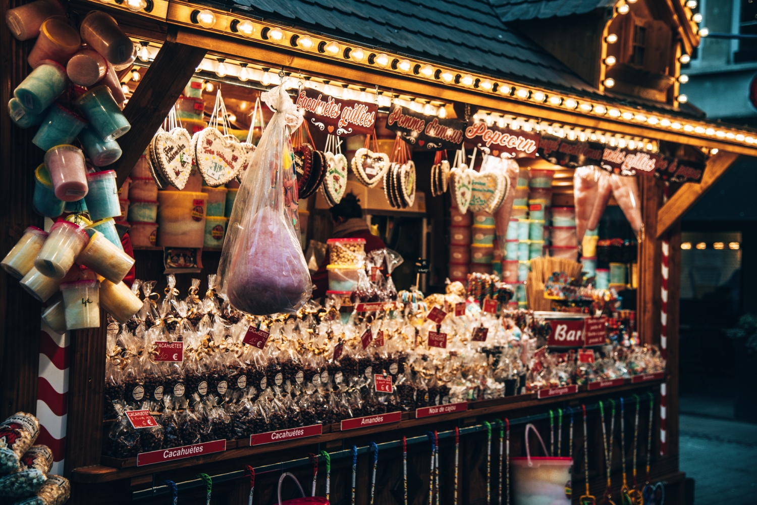 Verkaufsstand mit Süßigkeiten und Lebkuchenherzen auf einem Weihnachtsmarkt.