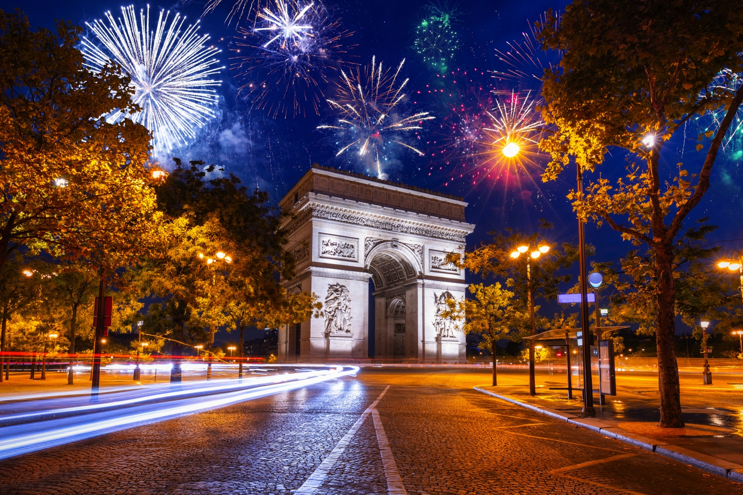 Triumphbogen bei Nacht mit Feuerwerk im Hintergrund