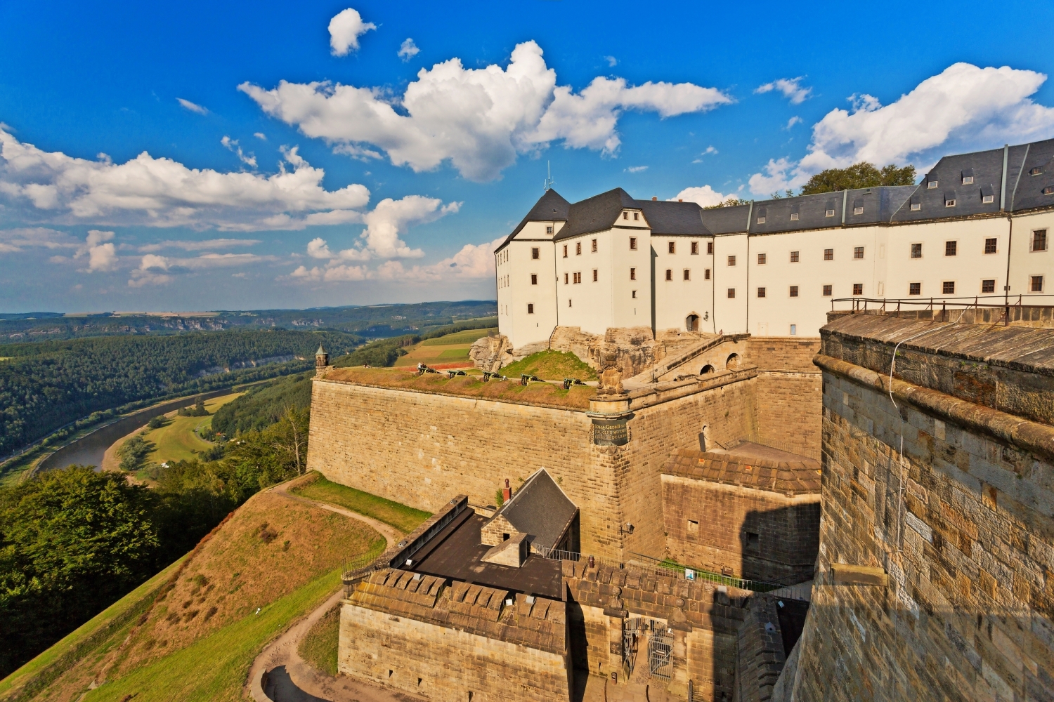 Elbsandsteingebirge Festung mit Fluss und Wald in der Ferne unter blauem Himmel.