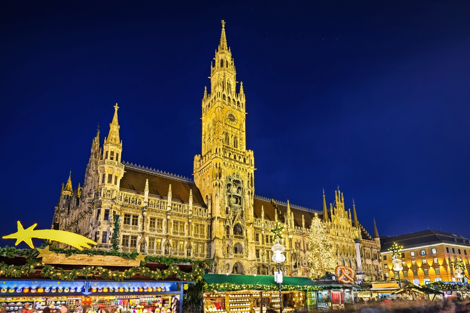 © Mapics - stock.adobe.com Neues Rathaus in München bei Nacht mit beleuchtetem Weihnachtsmarkt.