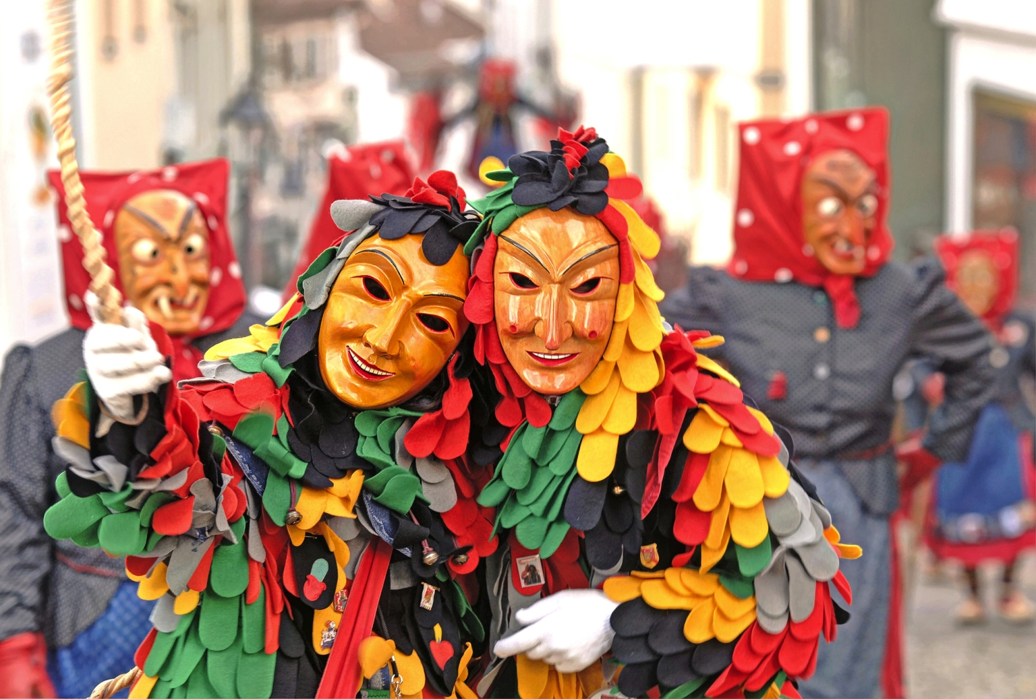 ©reinhard sester - stock.adobe.com Menschen in farbenfrohen Masken und Kostümen bei einem traditionellen Festumzug.